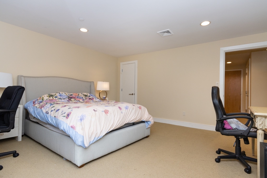 241 Perkins Street, Unit D302 Boston, MA 02130 - Photo 26 of 31 a bedroom with a bed a desk and chair