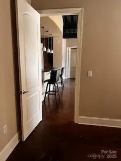 a view of a hallway with wooden floor and a cabinet