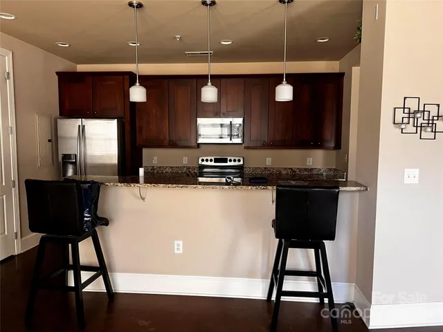a kitchen with a table chairs refrigerator and microwave