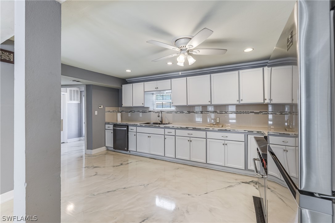 2885 Triggerfish Street Cape Coral, FL 33993 - Photo 7 of 35 a large kitchen with kitchen island a sink stainless steel appliances and cabinets