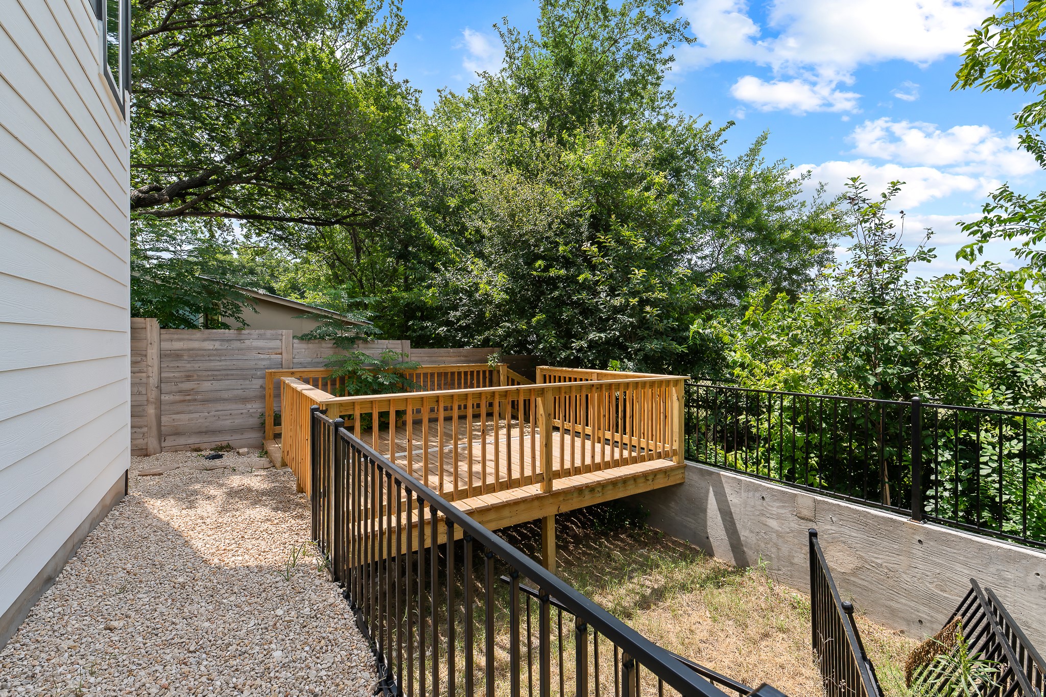 5305 Ledesma Road, Unit 4 Austin, TX 78721 - Photo 40 of 40 A spacious wooden deck extends into a lush, green yard, offering a peaceful outdoor retreat.