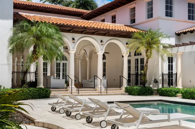 a front view of a house with swimming pool and garden