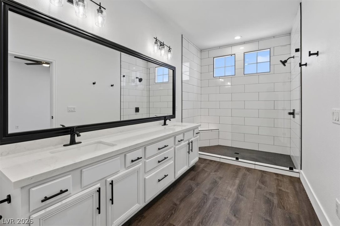 251 Integrity Ridge Drive Henderson, NV 89052 - Photo 12 of 32 Clean lines and rich wood-look flooring define this modern primary bathroom sanctuary.