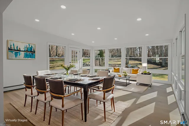 a view of a dining room and livingroom with furniture wooden floor and a rug