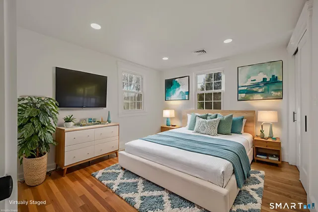 a bedroom with a large bed and a flat screen tv
