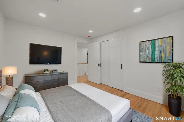 a bedroom with a bed and a flat screen tv