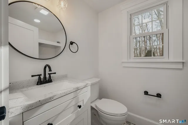 a bathroom with a toilet a sink and mirror