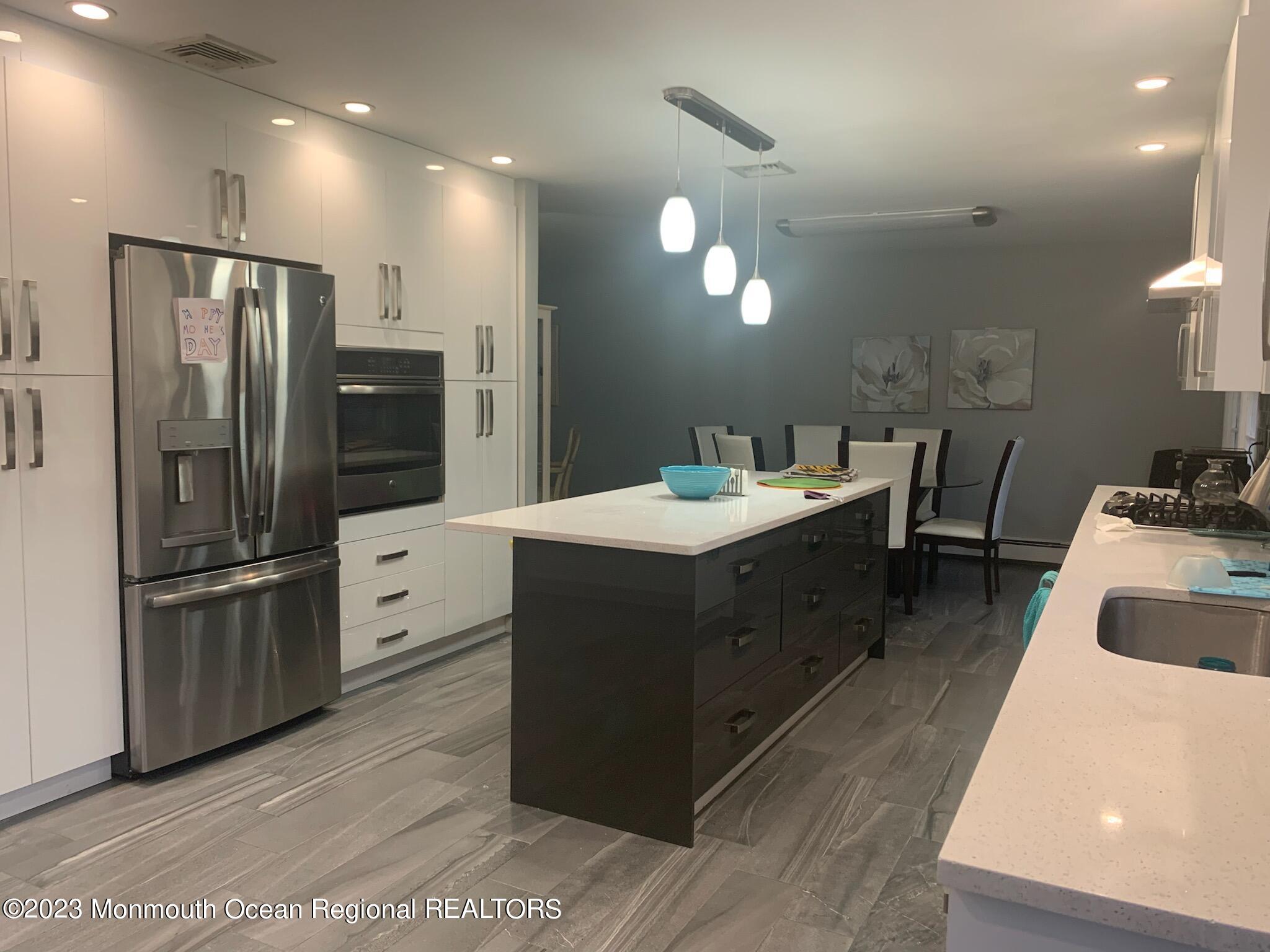 293 Lawrence Avenue Oakhurst, NJ 07755 - Photo 1 of 18 a kitchen with a refrigerator sink and wooden cabinets