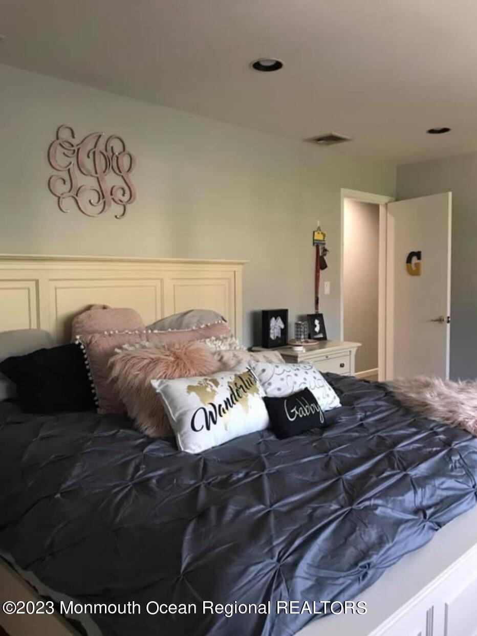 293 Lawrence Avenue Oakhurst, NJ 07755 - Photo 7 of 18 a bed sitting in a bedroom and wooden floor