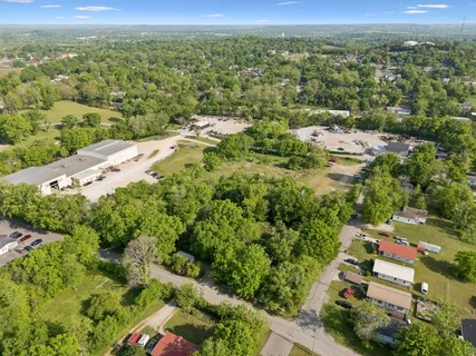 an aerial view of residential houses with outdoor space and trees