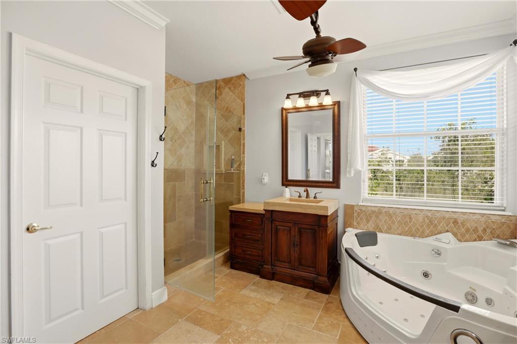 2150 Khasia Point Naples, FL 34119 - Photo 13 of 39 Full bathroom with a shower stall, vanity, a whirlpool tub, ornamental molding, and ceiling fan