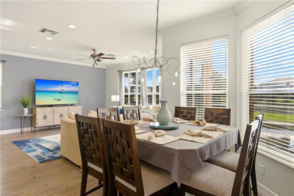 2150 Khasia Point Naples, FL 34119 - Photo 2 of 39 Dining room with crown molding, wood finished floors, recessed lighting, and ceiling fan