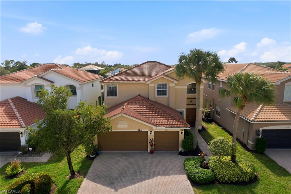 2150 Khasia Point Naples, FL 34119 - Photo 24 of 39 Mediterranean / spanish house featuring stucco siding, a tiled roof, decorative driveway, and a residential view