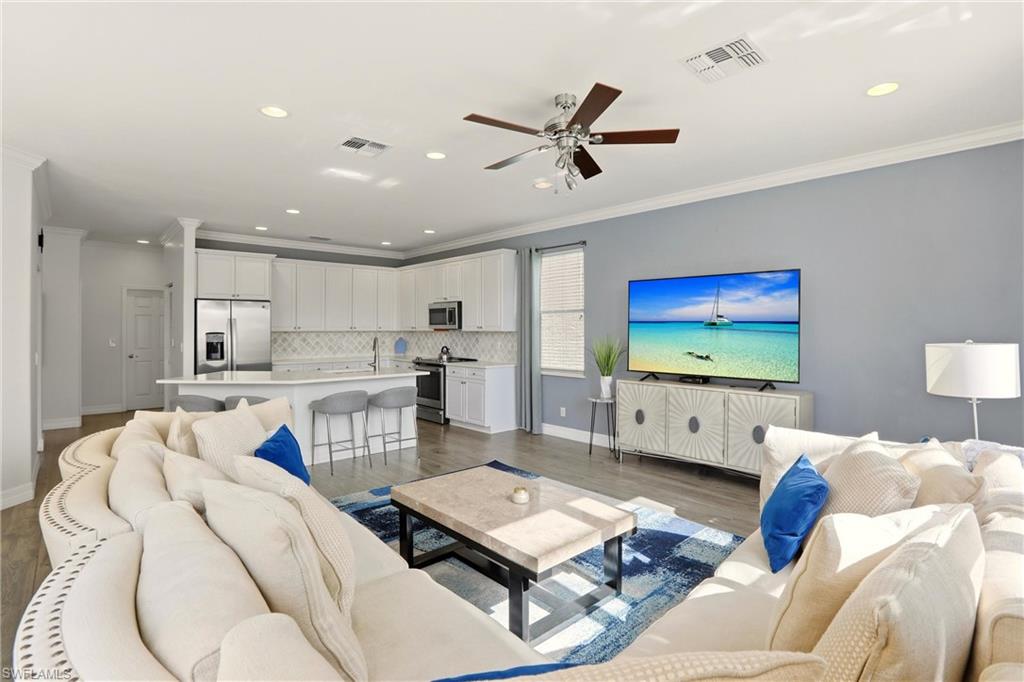 2150 Khasia Point Naples, FL 34119 - Photo 35 of 39 Living room with ornamental molding, recessed lighting, ceiling fan, and wood finished floors