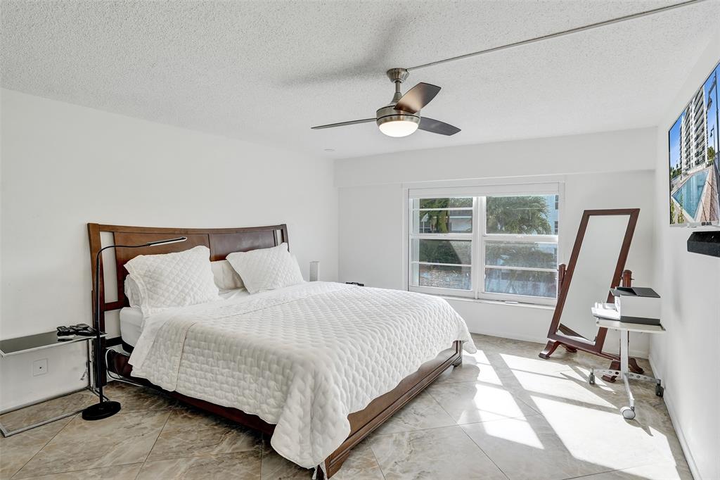 5100 Dupont Boulevard, Unit 3G Fort Lauderdale, FL 33308 - Photo 15 of 46 a bedroom with a bed a flat screen tv and a large window