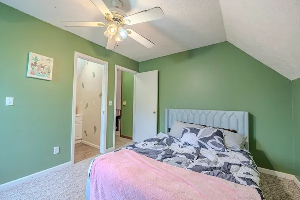 a bedroom with a large bed and a chandelier