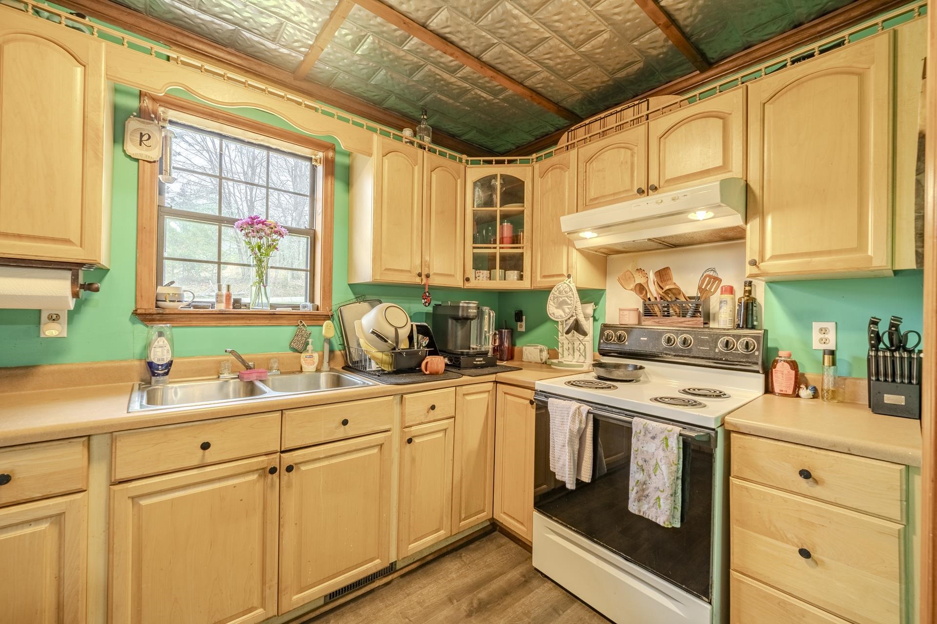 635 Pompeys Branch Road Savannah, TN 38372 - Photo 20 of 26 Kitchen with electric range, an ornate ceiling, glass fronted cabinets, light countertops, and light wood finish cabinetry