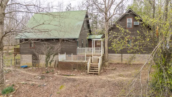 a front view of a house with a tree
