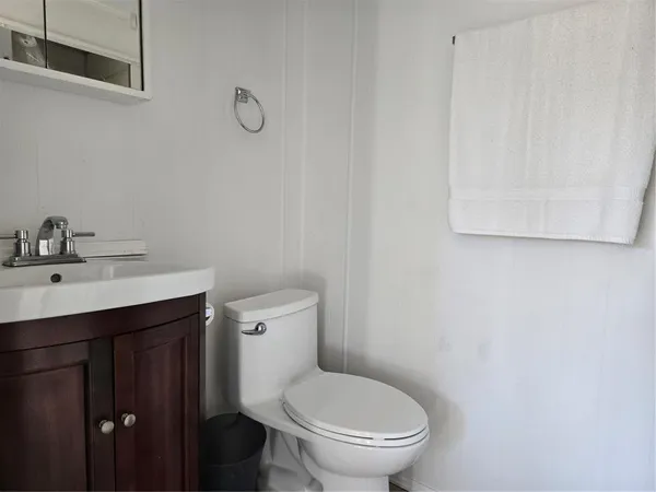 a bathroom with a toilet a sink and mirror