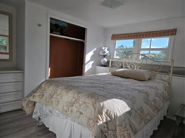 a bedroom with a bed and a large window