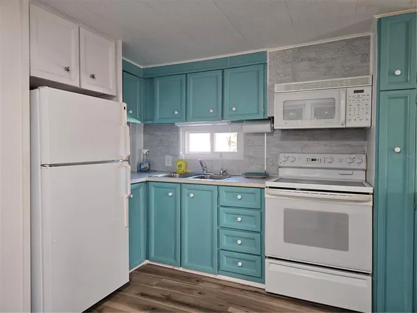 a kitchen with cabinets a refrigerator and a stove