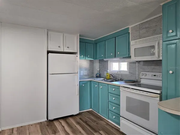 a kitchen with a refrigerator sink and cabinets