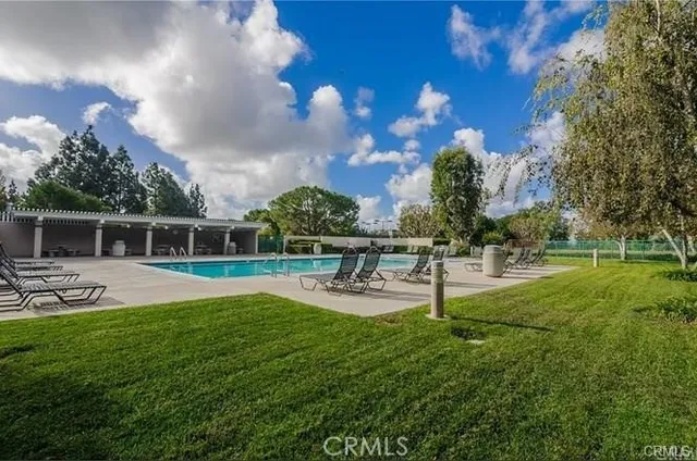 a swimming pool with outdoor seating and yard in the back
