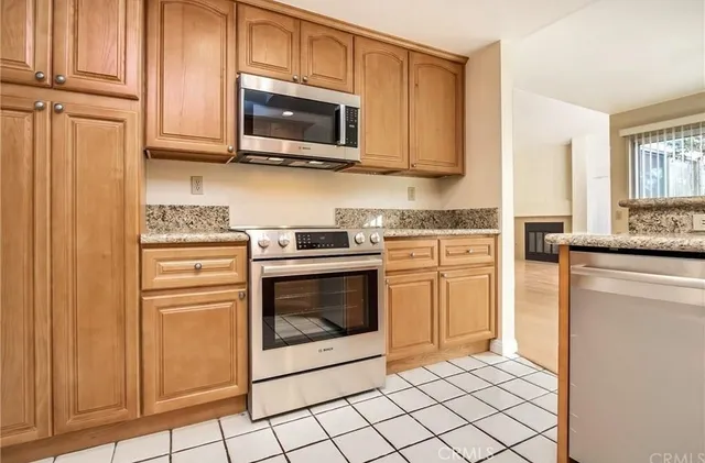 a kitchen with stainless steel appliances granite countertop a stove microwave and cabinets