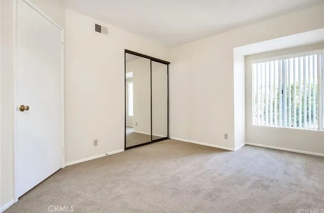an empty room with windows and closet