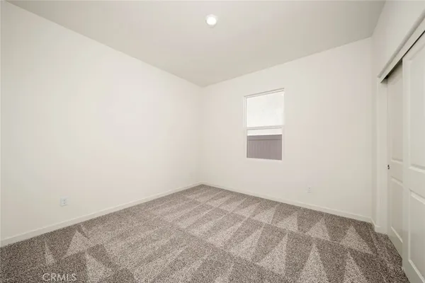 an empty room with wooden floor and a bathroom