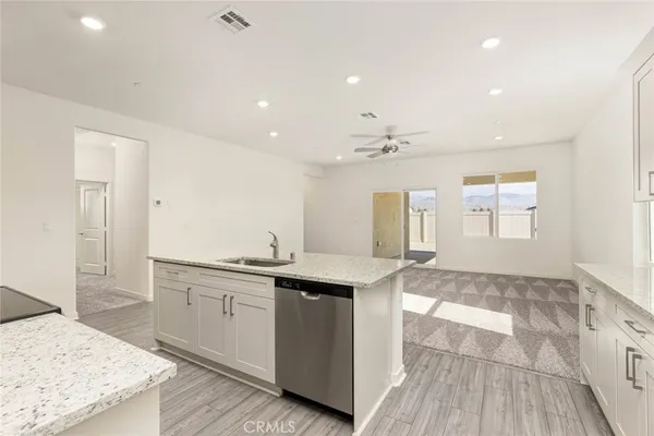 a kitchen with granite countertop a sink and cabinets with wooden floor