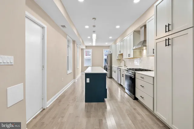 a kitchen with stainless steel appliances granite countertop a refrigerator a sink and a stove