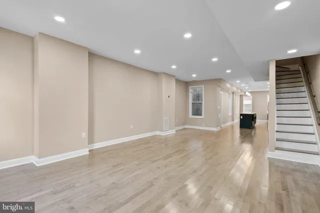 a view of an empty room with wooden floor