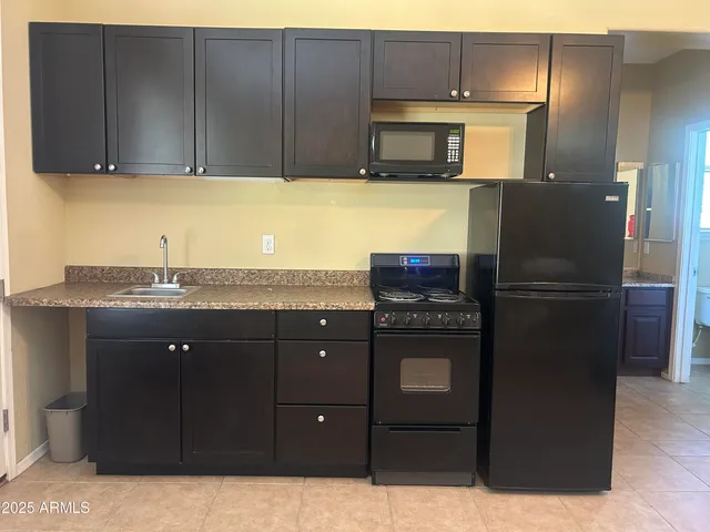 a kitchen with a refrigerator and cabinets