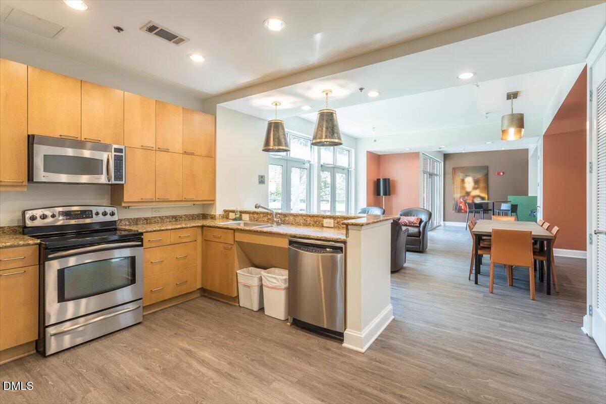 618 North Boylan Avenue, Unit 924 Raleigh, NC 27603 - Photo 27 of 33 a kitchen with stainless steel appliances kitchen island granite countertop a stove a sink and a refrigerator