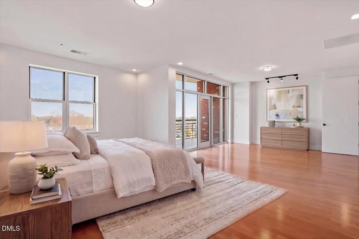 618 North Boylan Avenue, Unit 924 Raleigh, NC 27603 - Photo 3 of 33 a spacious bedroom with a bed and wooden floor