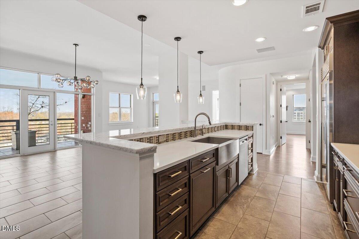618 North Boylan Avenue, Unit 924 Raleigh, NC 27603 - Photo 6 of 33 a large kitchen with a large counter top a sink stainless steel appliances and cabinets