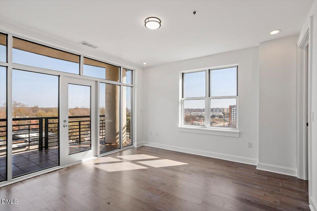 618 North Boylan Avenue, Unit 924 Raleigh, NC 27603 - Photo 10 of 33 an empty room with wooden floor and windows