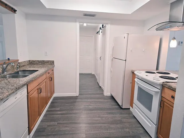 a kitchen with granite countertop a sink and a stove top oven