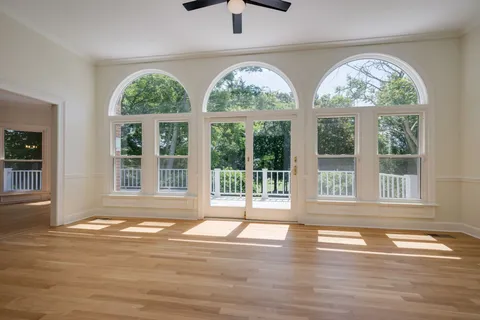 a view of a living room and a balcony wooden floor