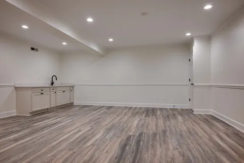 a view of backyard with large trees and wooden floor
