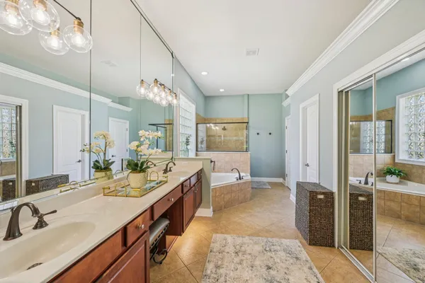 a spacious bathroom with a double vanity sink a mirror and a shower