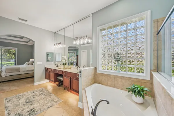 a large spacious bathroom with a tub sink and mirror