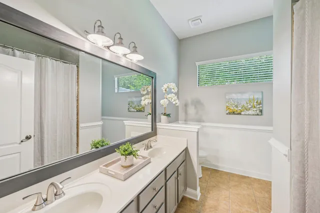 a bathroom with a granite countertop sink a large mirror and a shower