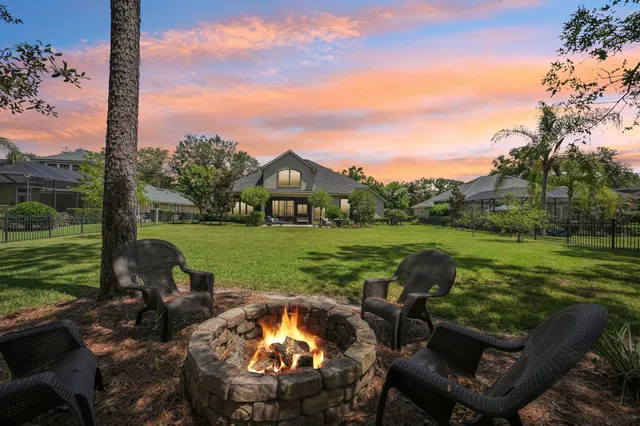 a view of a swimming pool and lounge chairs in back yard of the house