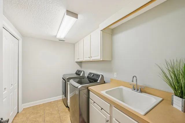 a utility room with sink dryer and washer