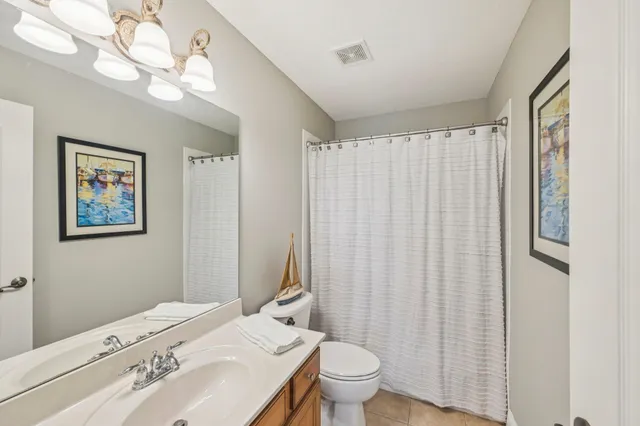 a bathroom with a sink a toilet and shower curtain