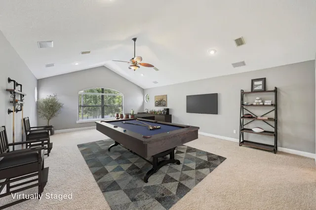 a living room with furniture a flat screen tv and a table