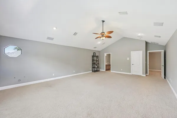 an empty room with a ceiling fan and window