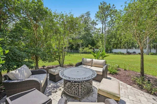 a view of a patio with a table chairs and a yard